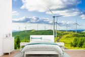 Behang - Fotobehang Een veld van windmolens in de groene natuur - Breedte 330 cm x hoogte 220 cm