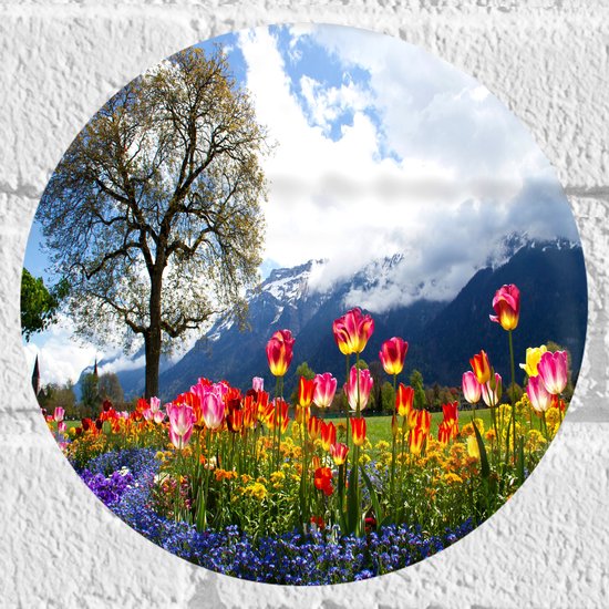 WallClassics - Muursticker Cirkel - Felgekleurde Bloemen in het Veld met Berg en Boom - 20x20 cm Foto op Muursticker