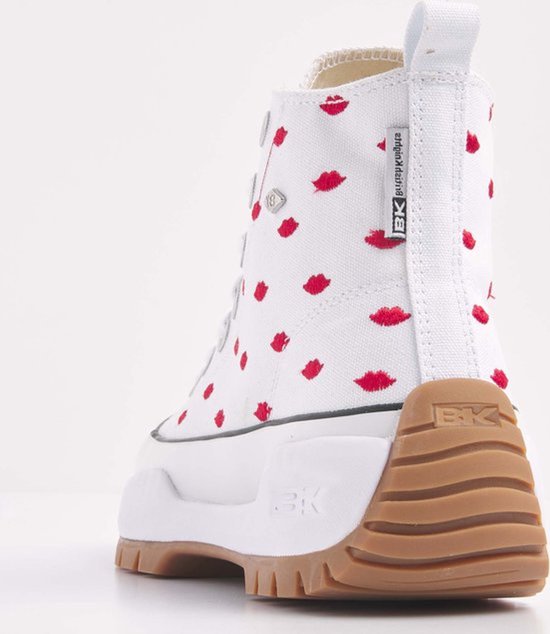 Achterkant van een witte hoge sneaker met rode lippenprint, bruine zool en logo.