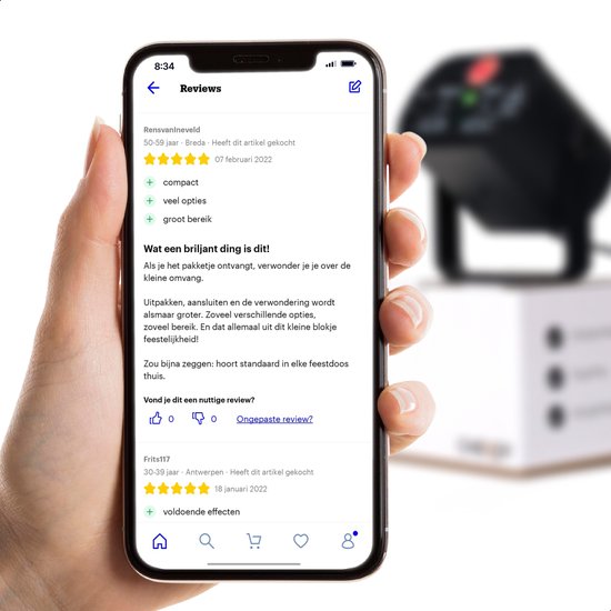 Main tenant un smartphone avec des avis sur la lumière de fête Cheroy, une lumière de fête en arrière-plan.