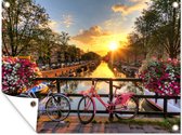 Tuinposter - Tuindoek - Tuinposters buiten - Amsterdam - Bloemen - Brug - Fiets - Zonsondergang - 120x90 cm - Tuin