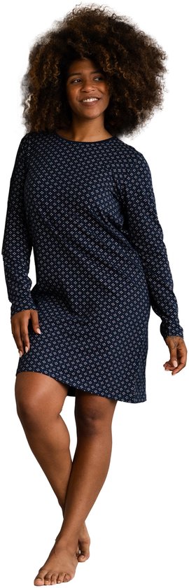 Donkerblauw nachthemd met lange mouwen en een all-over patroon van kleine witte vierkantjes, gedragen door een vrouw.