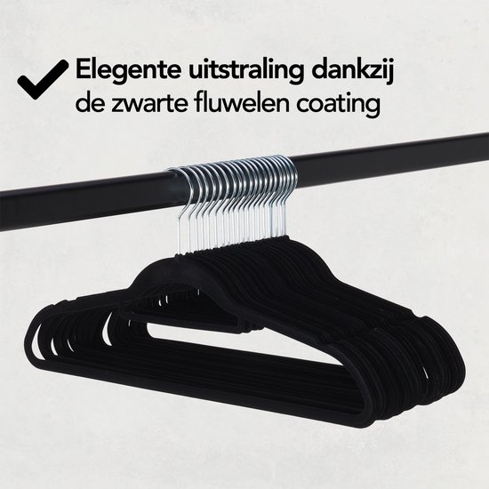 Zwarte fluwelen kledinghangers hangen aan een zwarte kledingroede.