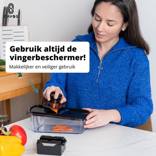 Vrouw gebruikt de Cavos mandoline met wortel, met de vingerbeschermer ingeschoven.