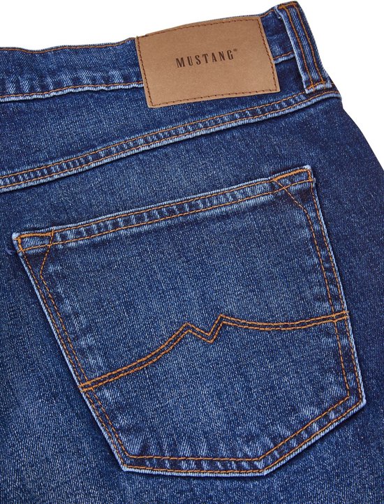 Achterzak van blauwe jeans met oranje stiksels en bruin Mustang label.