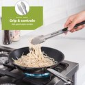 Hand gebruikt RVS tang met geschulpte randen om pasta uit een pan te scheppen.