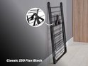 Ingeklapt zwart Classic 250 Flex droogrek leunend tegen een grijze muur, met detail van de klem. 