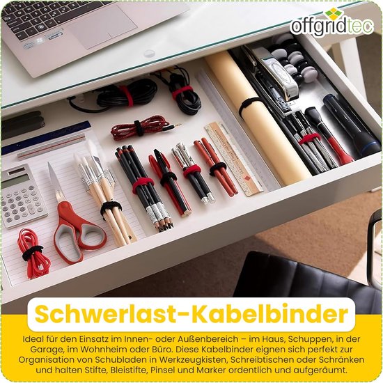 Een open bureaulade met diverse kantoorbenodigdheden, waaronder pennen, potloden, scharen en opgerolde kabels met rode en zwarte kabelbinders.