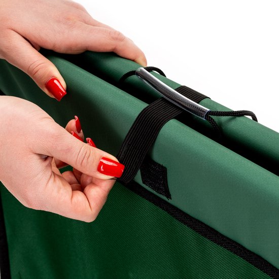 Vrouwenhanden met rode nagellak die de elastische band van de opvouwbare kruiwagen vastpakken.
