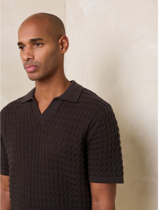 Man met kort bruin poloshirt met visgraatpatroon en V-hals.