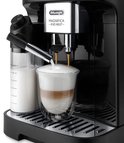 Zwarte volautomaat zet een latte macchiato in een glas met dubbele wand. Melkreservoir naast de machine.
