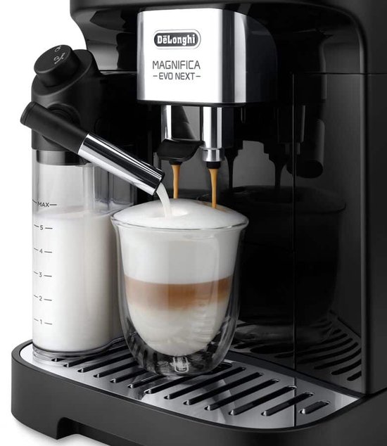 Zwarte volautomaat zet een latte macchiato in een glas met dubbele wand. Melkreservoir naast de machine.