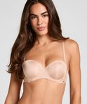 Model draagt een beige balconette bh met kanten details op de cups.