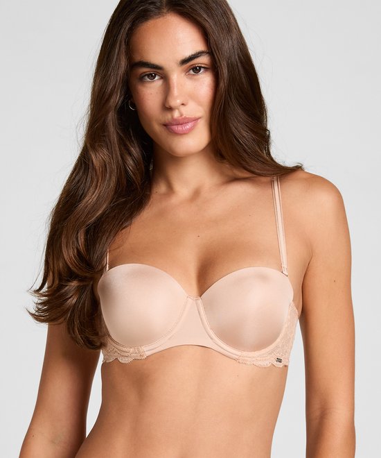 Model draagt een beige balconette bh met kanten details op de cups.
