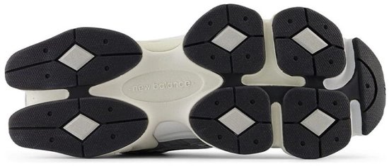 Onderkant van een New Balance 9060 sneaker, met beige en zwarte zool met diamantvormig profiel.