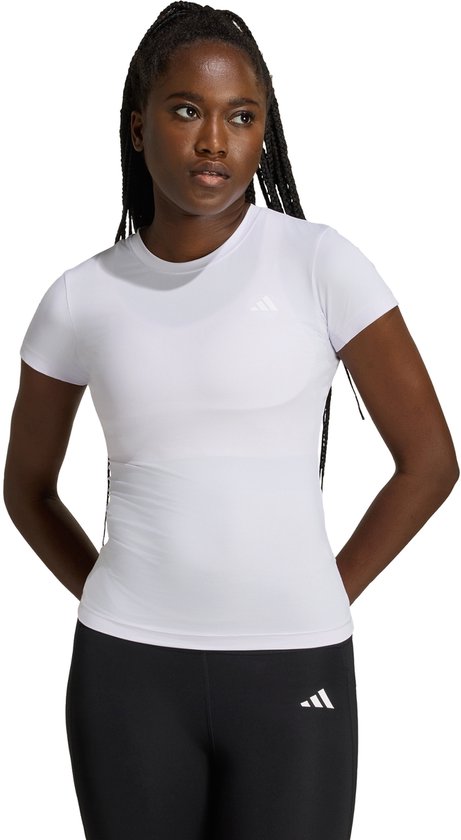Wit sportshirt met korte mouwen, gedragen door een vrouw met zwarte legging en handen achter de rug.