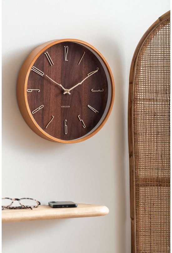 Wandklok met een houten frame en donkerhouten wijzerplaat met gouden cijfers. Inclusief bril en telefoon.