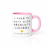 Witte mok met roze oor en binnenkant. Tekst: 'i used to work with ABSOLUTE LEGENDS' met een gele ster. Onderaan: '(yes, they bought me this mug...)'