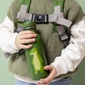 Groene drinkfles met Mr. Alligator print en witte stippen, gedragen door een kind met rugzak.