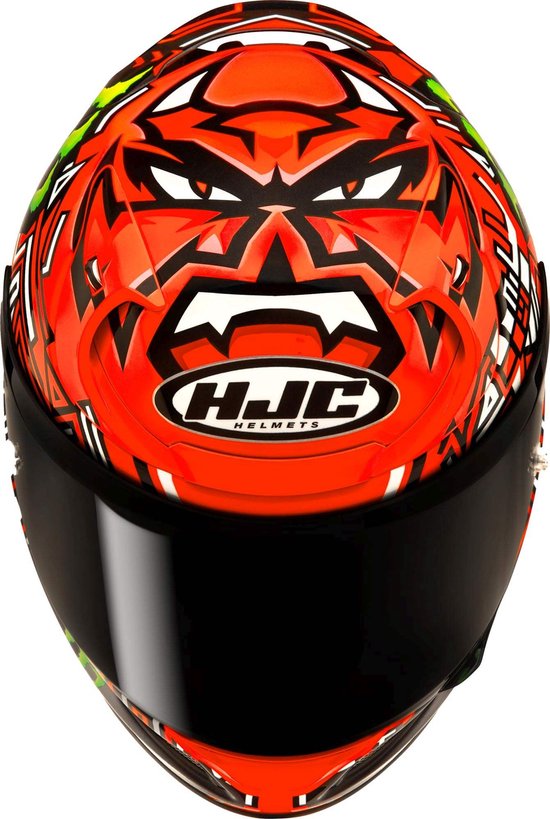 HJC motorhelm met zwart vizier, oranje voorzijde met demonengezicht en Monster Energy logo's.