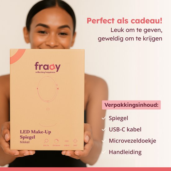 Vrouw houdt Fraay LED make-up spiegel Nikkel verpakking omhoog. Inhoud: spiegel, USB-C kabel, microvezeldoekje, handleiding.
