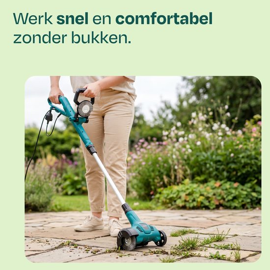 Een persoon gebruikt de elektrische onkruidborstel op een stenen terras, met veel groen in de achtergrond.