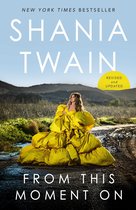 Boek 'From This Moment On' van Shania Twain, met een vrouw in een grote gele jurk in een landelijke omgeving.
