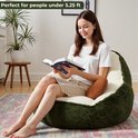 Een jonge vrouw zit in een groene avocadovormige zitzak.
