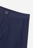Detail van de donkerblauwe boxershort: elastische tailleband met een wit logo en naden.