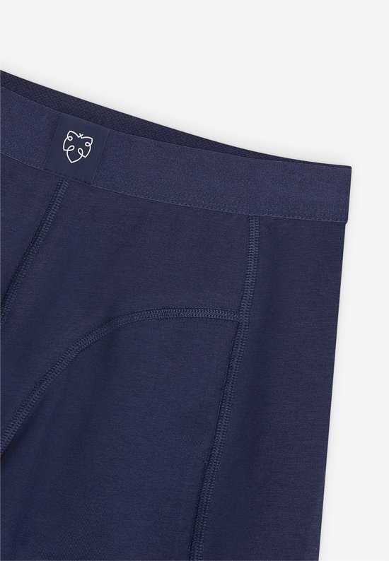Detail van de donkerblauwe boxershort: elastische tailleband met een wit logo en naden.