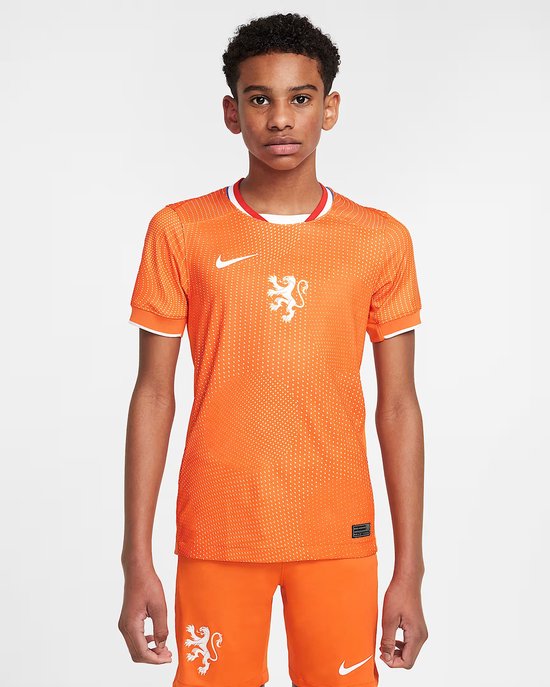 Voorkant van oranje KNVB voetbalshirt met wit stippenpatroon, wit Nike logo en leeuwembleem.