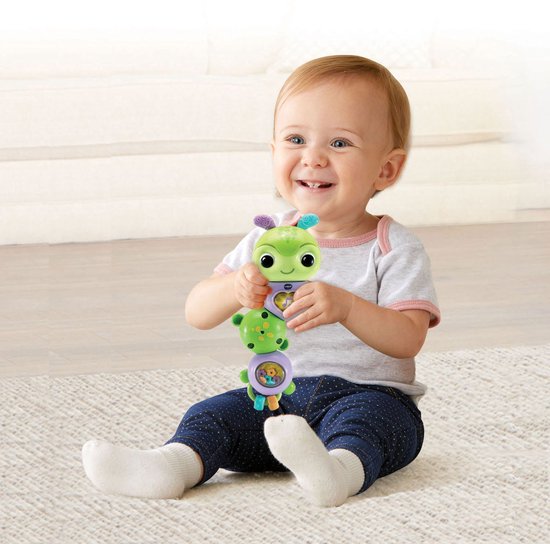 Baby met een groen rupsje in de handen.