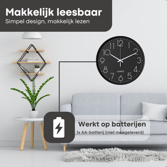 Zwarte wandklok met witte cijfers in een woonkamer met bank en planten.