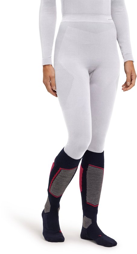 Vrouw in thermobroek en skisokken met rode en grijze vlakken. Schuine opname.