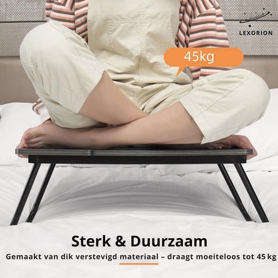 Persoon zittend op een laptoptafel die 45kg kan dragen, van verstevigd materiaal.