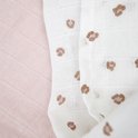 Witte hydrofiele luier met bruine panterprint liggend op een zachtroze luier.