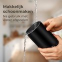 Zwarte melkopschuimer wordt met water omgespoeld voor eenvoudige reiniging.