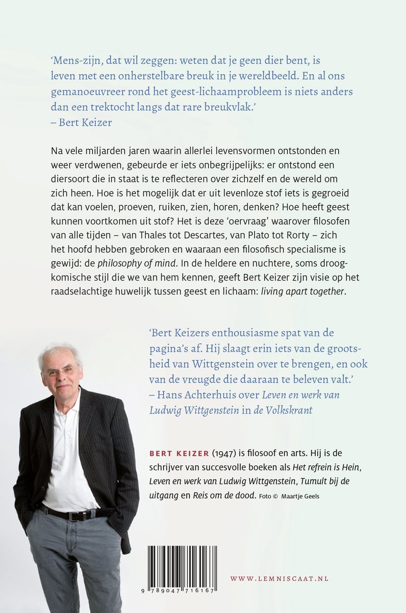 Bert Keizer in donker pak met wit overhemd en grijze sjaal, met grijze haar, bril.