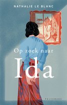 Boek "Op zoek naar Ida" van Nathalie Le Blanc. Een vrouw met een blauwe trui en rode broek staat met de rug naar ons toe voor een schilderij.