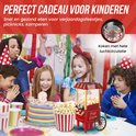 Kinderfeestje met rode popcornmachine, kinderen met popcorn. Feestelijke sfeer met ballonnen en hoedjes.