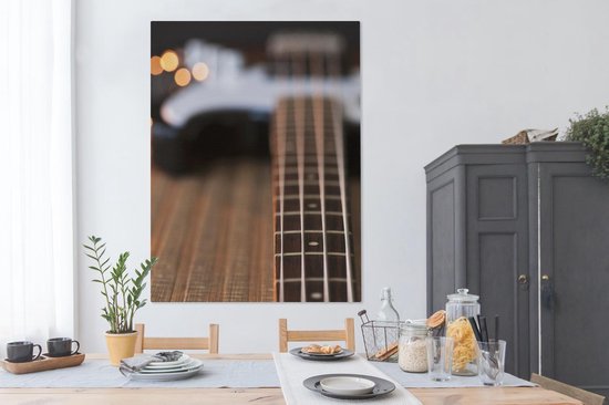 Une guitare basse repose sur le sol Toile 120x160 cm - Tirage photo sur toile (Décoration murale salon / chambre) XXL / Groot format!