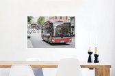 Canvas Schilderij Een vooraanzicht van een roodgekleurde bus - 60x40 cm - Wanddecoratie