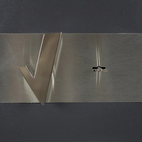 Close-up van een metalen plaat met zilverkleurig 'V'-logo en sleutelgat op een grijze kluis.