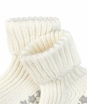 Detailopname van de boorden van witte gebreide babysokjes.