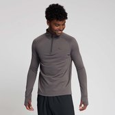 Grijze longsleeve met rits, een subtiel rasterpatroon en duimgaten. Model lacht en kijkt naar beneden.