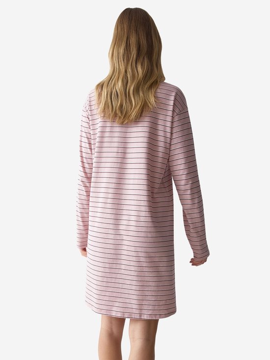 Draaiend model, van achteren gezien, in roze nachthemd met lange mouwen en fijne zwarte streepjes.