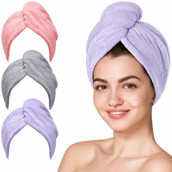 Vrouw met gezichtscrème draagt een paarse haarhanddoek met knoop, naast roze, grijze en paarse haarhanddoeken.