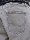 Close-up van de achterkant van grijze jeans met een merklogo op de zak.