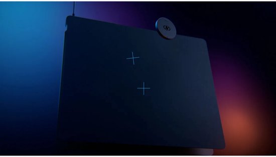 Zwarte muismat met lichtgevende kruisjes en een oplaadmodule in een sfeervolle, donkere verlichting.