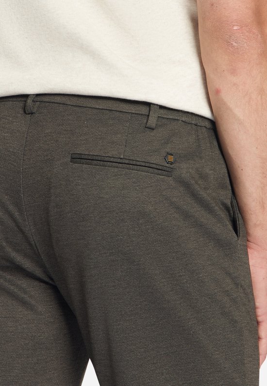 Close-up van de achterkant van een donkerbruine jersey pantalon met paspelzak en logo.